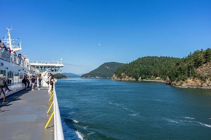 Blick von einem Fährdeck auf bewaldete Inseln an einem sonnigen Tag