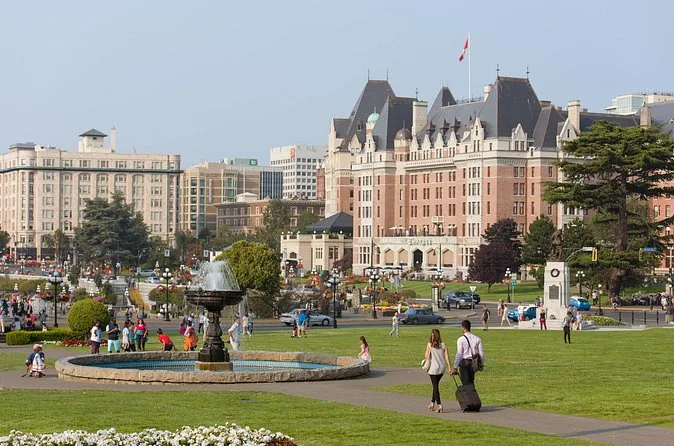 Das Hotel Fairmont Empress über einem Springbrunnen und Rasen am Inner Harbour von Victoria